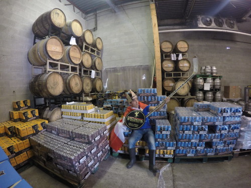 Erik Seiji Yamamoto stands in a king costume in the middle of pallets stacked with Wellington beer cans