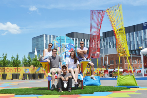 Luísa Cassol Pasqualotto poses with fellow interns in a Pan Am games chair, Toronto 2015